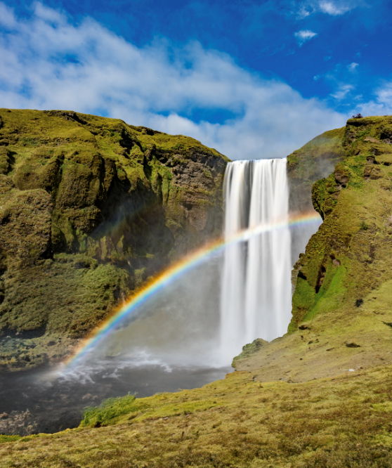 A rainbow over a waterfall Description automatically generated