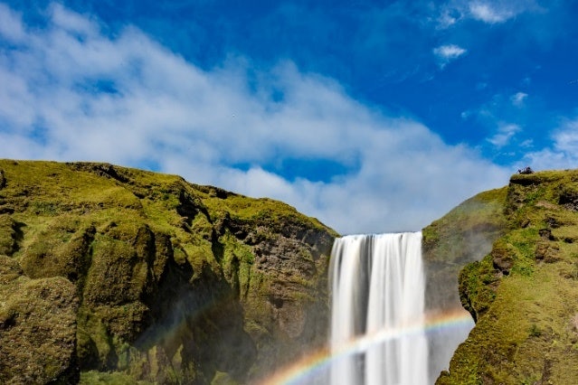 A rainbow over a waterfall Description automatically generated