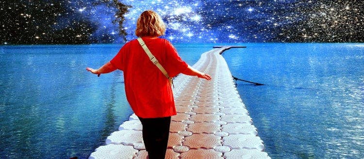 Surrealistic collage. A person walks along the ocean against the background of stars and galaxies