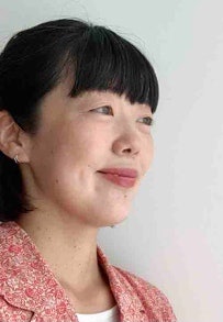 ピンクのシャツを着ている女性の顔 自動的に生成された説明