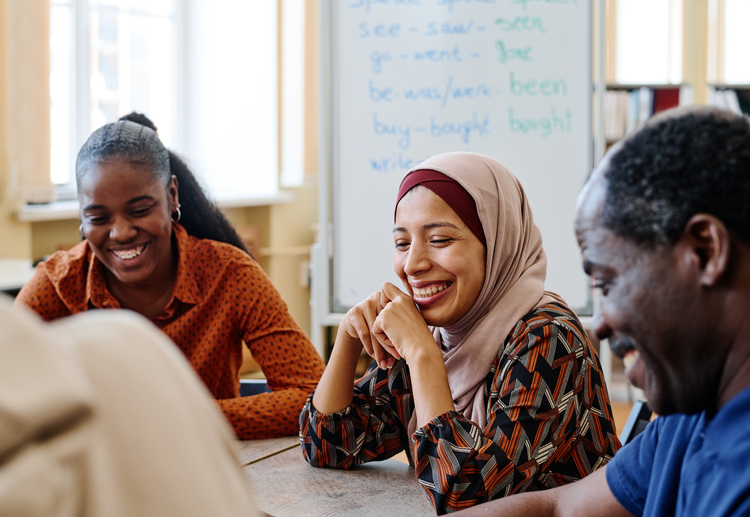 Image of three people smiling at a table.