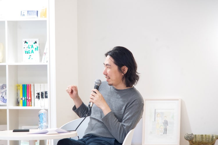 A person sitting in a chair holding a microphone Description automatically generated