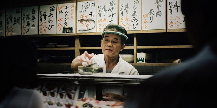寿司を提供する男性