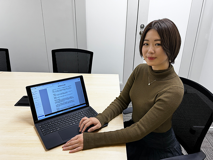 A person sitting at a table with a computer Description automatically generated