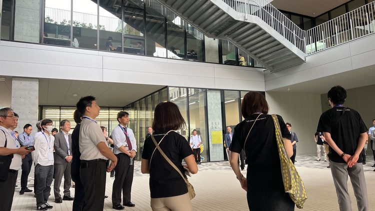 建物の前を歩く人々 中程度の精度で自動的に生成された説明