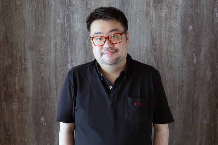 黒いシャツを着た男性 自動的に生成された説明