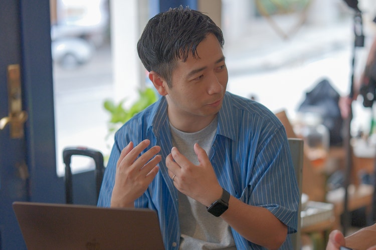 テーブルに座っている男性 中程度の精度で自動的に生成された説明