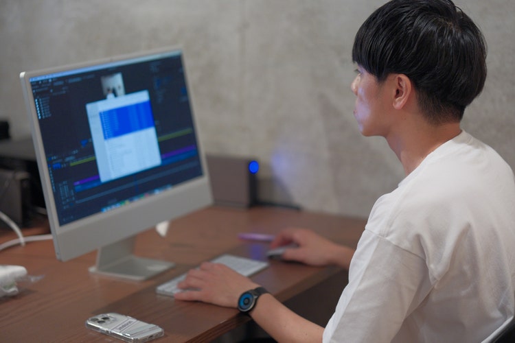 コンピューターを使っている男性 低い精度で自動的に生成された説明