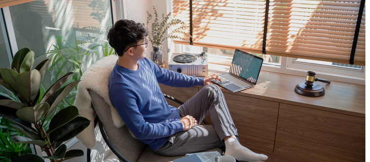 A person sitting in a chair using a computer Description automatically generated