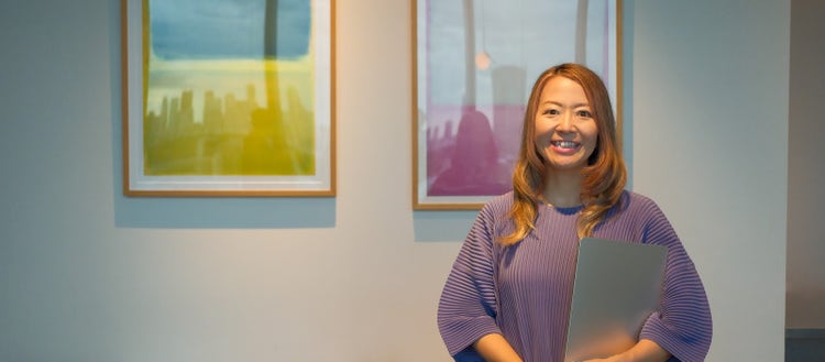 白い壁の前に立っている女性 自動的に生成された説明