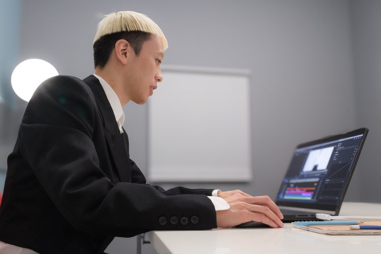 ノートパソコンを使っている男性 中程度の精度で自動的に生成された説明