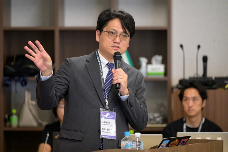 A person in a suit holding a microphone AI-generated content may be incorrect.
