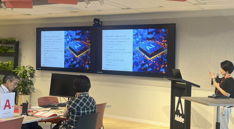 A person sitting at a desk with a large screen on the wall AI-generated content may be incorrect.