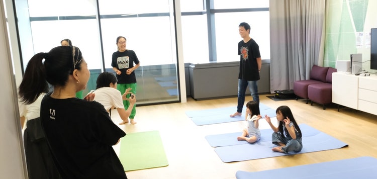 ヨガマットの上で、親子でヨガに参加しているリラクゼーションプログラムの様子