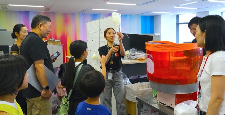 会場内でわたあめを受け取り、軽食を楽しむ参加者の様子