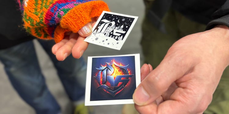 来場者が手にした2枚のステッカー。モノクロのシンプルなデザインと、炎をまとったダイナミックなデザイン。同じロゴベースでもプロンプト次第でまったく異なる表情に