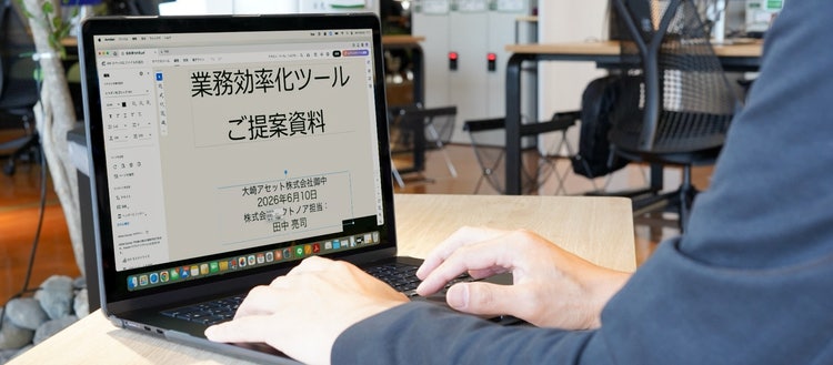 ノートPCに表示されたPDF提案資料を確認する作業イメージ
